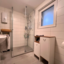 Badezimmer mit verglaster Dusche, Fenster und Durchlauferhitzer